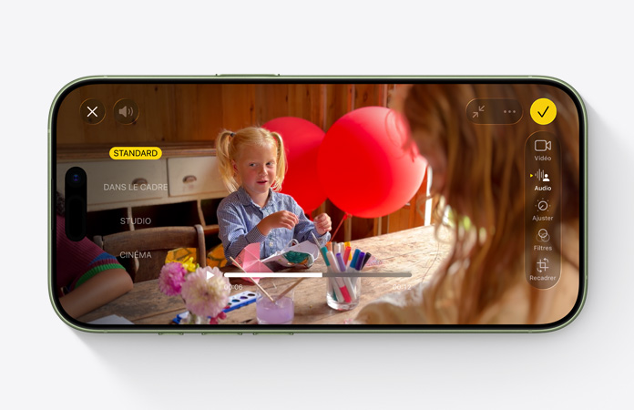 iPhone 17, face avant, vidéo avec la fonctionnalité mix audio activée, montrant une enfant assise à une table en train de jouer avec des ballons