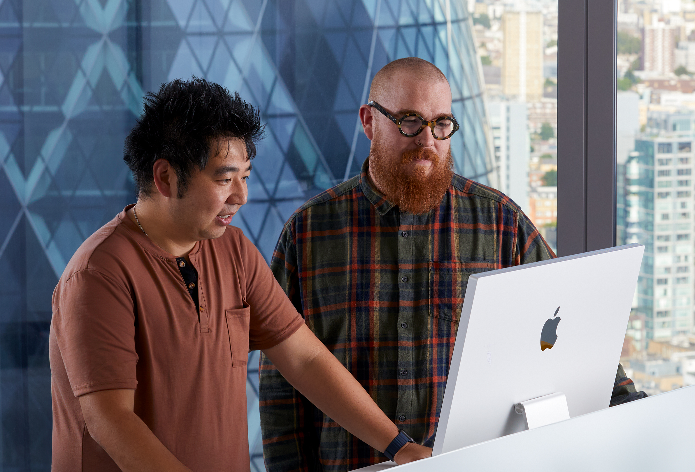 兩位 Apple 同事使用 iMac 協作。