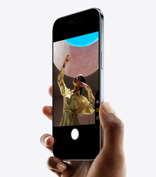 Eine Hand hält ein iPhone Air mit dem Daumen auf der Taste für die Kamerasteuerung, Vorderseite, Seite, dünnes Profil, Dynamic Island, Seitentaste