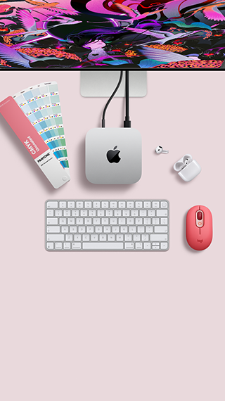 Mac mini, από πάνω, ασημί αλουμίνιο, στρογγυλεμένες γωνίες, γυαλιστερό μαύρο λογότυπο Apple στο κέντρο, συνδεδεμένο με καλώδιο, οθόνη Studio Display μερικώς ορατό από πάνω, AirPod 4, ανοιχτά, δείγματα χρωμάτων Pantone, αριθμητικό πληκτρολόγιο και ποντίκι