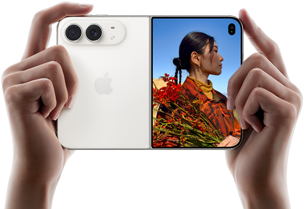 iPhone Duo, zvjezdano bijele boje, drži se dvjema rukama u vodoravnoj orijentaciji, otvoren, lijevi panel prikazuje stražnje dvojne kamere Fusion od 48 MP, desni panel prikazuje osobu koja snima fotografiju na vanjskom zaslonu, objekt fotografije može vidjeti svoje lice dok se fotografija snima koristeći Duo Preview