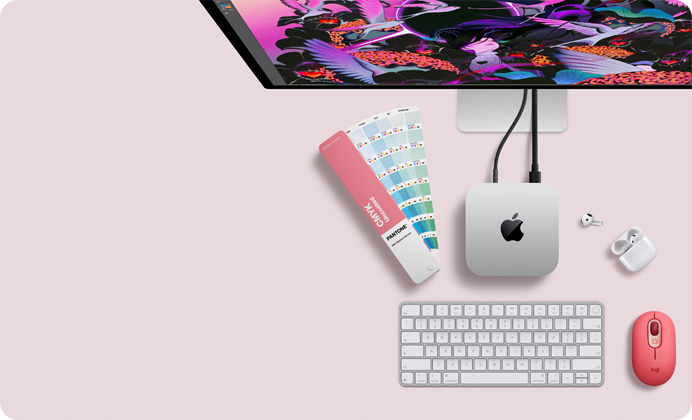 Mac mini, odozgo, srebrni aluminij, zaobljeni uglovi, sjajni crni Appleov logotip u sredini, povezan kabelom, Studio Display djelomično vidljiv odozgo, AirPod 4, otvoren, Pantone skala boja te numerička tipkovnica i miš