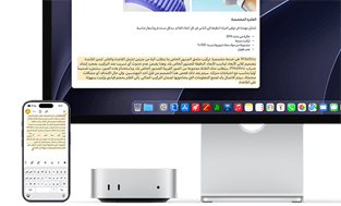 الجهة الأمامية لجهاز Mac mini، موضوع تحت شاشة Studio Display، جهاز iPhone موضوع على يمين الجهاز والشاشة، نص محدد مع أوامر القص والنسخ واللصق والتعبئة التلقائية في الجهة العلوية من iPhone يتطابق مع النص المظلل على الشاشة، في استعراض للحافظة العامة