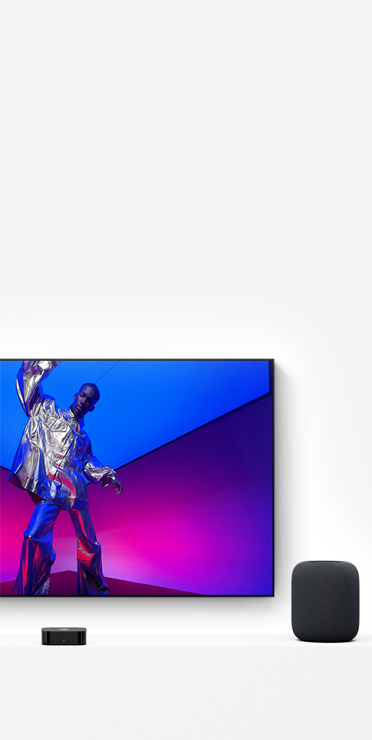 Apple TV 4K and HomePod, midnight colour, TV screen shows a performer in a metallic silver outfit
