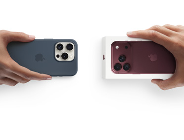 Hænder bytter en iPhone 13 med silikonecover og klistermærker på bagsiden til en ny iPhone 18 i en æske.