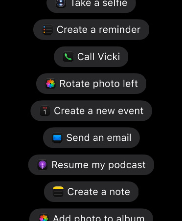 Skærm med anmodninger til Siri AI om at foretage handlinger i apps, herunder Tag en selfie, Opret en påmindelse, Ring til Vicki, Roter foto til venstre, Opret en ny begivenhed, Send en mail, Fortsæt min podcast, Opret en note, Tilføj foto til album