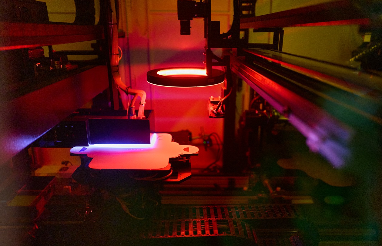 Manufacturing equipment illuminated by red and blue light in a factory
